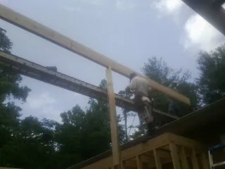 Carpenter setting a ridge beam over a new addition frame — Ice Dam Removal by Roofing Brothers in Shepherdsville