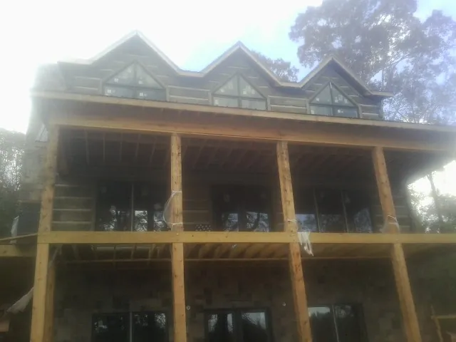 Dormers and porch framing on a large log home under construction — Roof Coating work by our crew in Shepherdsville