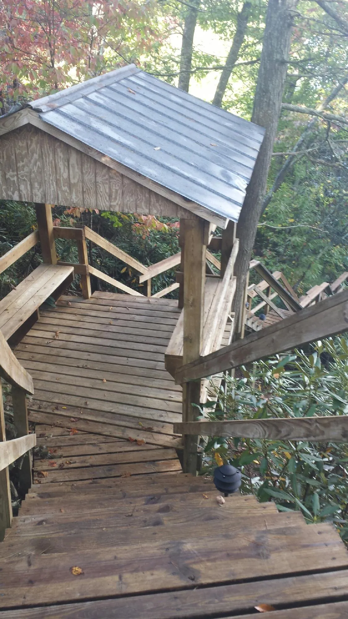 Metal roofed shelter over wooden steps on a wooded walkway — Skylight Repair & Installation work by our crew in Shepherdsville